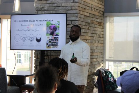 Clyde Tsianguebeni, senior health services major shows off the beard grooming products he uses Monday at Authentically Me's "Rock the Wrap" seminar in the Traditions Lounge. (Photo by Bryce West)