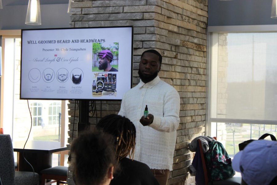 Clyde Tsianguebeni, senior health services major shows off the beard grooming products he uses Monday at Authentically Mes Rock the Wrap seminar in the Traditions Lounge. (Photo by Bryce West)