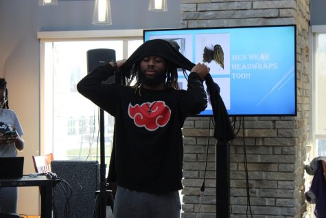 Jhohaarie Gray, sophomore marketing major, demonstrates how he puts on a headwrap Monday at Authentically Me's "Rock the Wrap" seminar in the Traditions Lounge. (Photo by Bryce West)