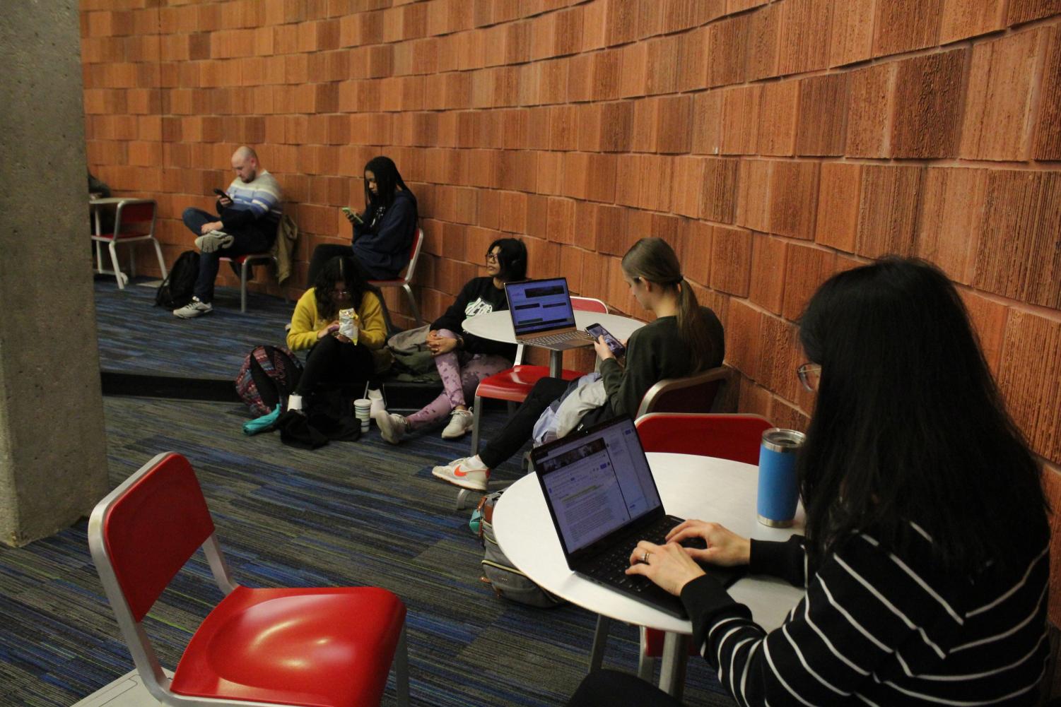 Students sit and continue to work after being evacuated around 12:25 p.m. Friday to the University Center East basement.