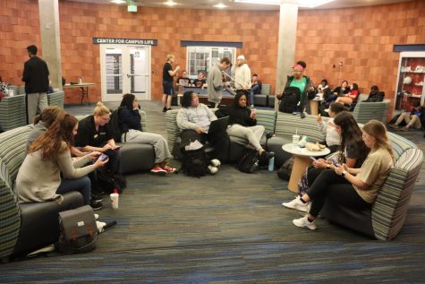 Students sit in the basement of University Center East after being evacuated during the tornado warning at 12:30 on Friday.