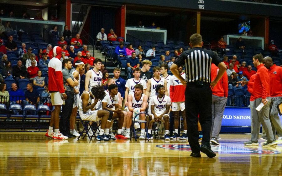 The mens basketball team sits on the court during a media timeout against Midway University Nov. 7, 2022, in the Screaming Eagles Arena.