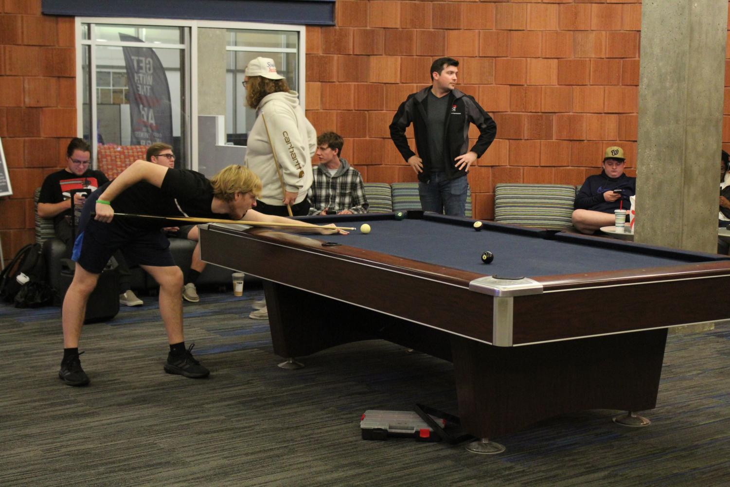 Students continue to play pool after other students and faculty were evacuated around 12:15 p.m. to the University Center East basement Friday. (Photo by Emalee Jones)