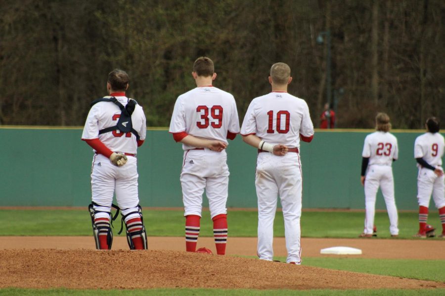 Tyler Kapust, junior catcher, Will Kiesel, freshman pitcher, and Jack Ellis, junior infielder, stand for the national anthem Thursday in the game against Southeast Missouri State University at the USI Baseball Field.