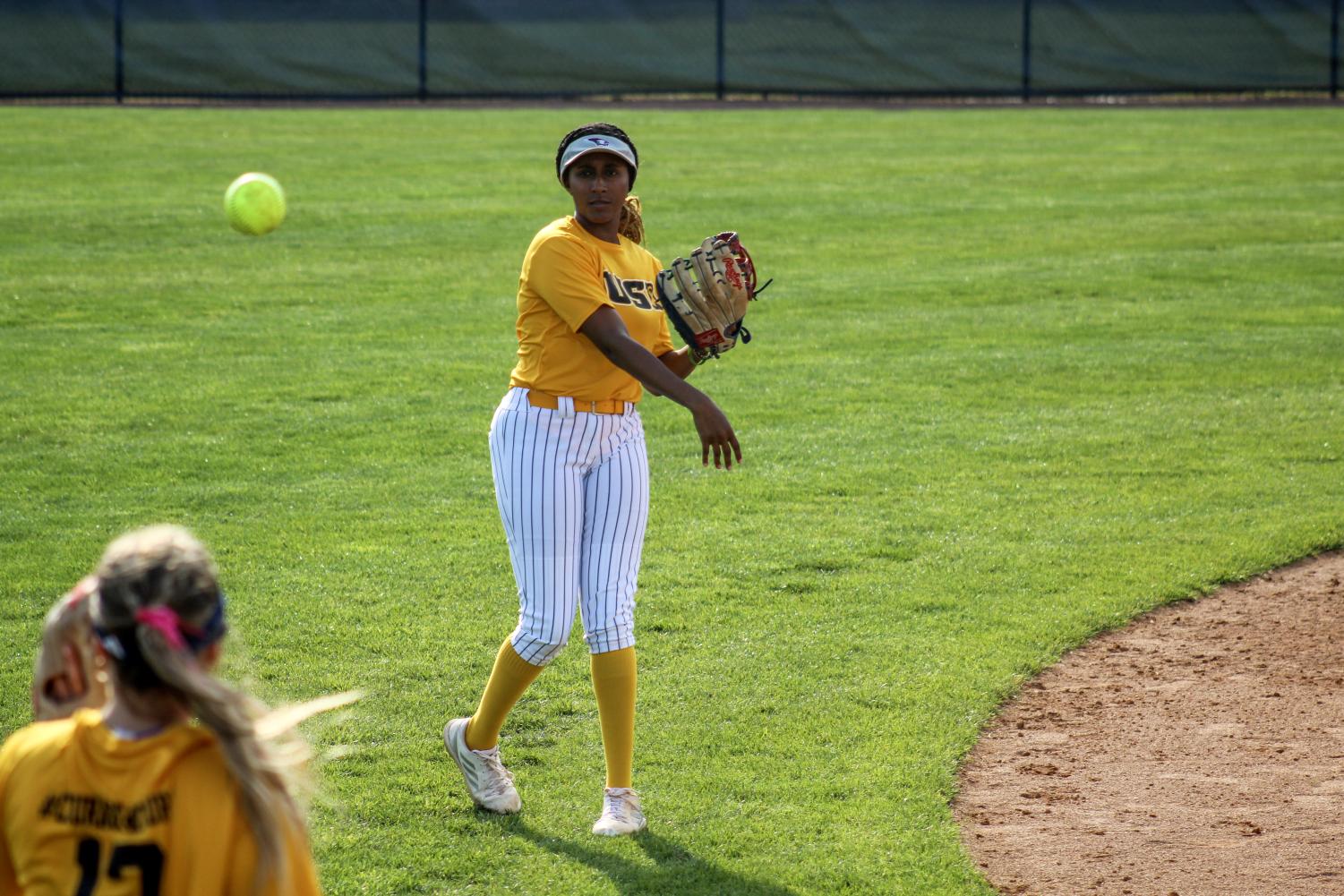 Olivia Howard, sophomore outfielder, throws a softball to Kennedy Nalley, sophomore utility player, April 4 in the game against Indiana University-Purdue University Indianapolis at the USI Softball Field.