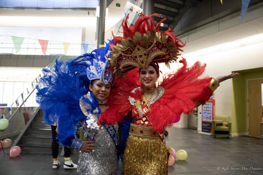 Lendy Domínguez, freshman biochemistry major and the queen representing University Center West, and Matea Rodovic, senior biochemistry major and the queen representing University Center East, smile in their costumes at the Panamanian Carnival Thursday in the Business and Engineering Building. (Photo by Kyla Dagatan)