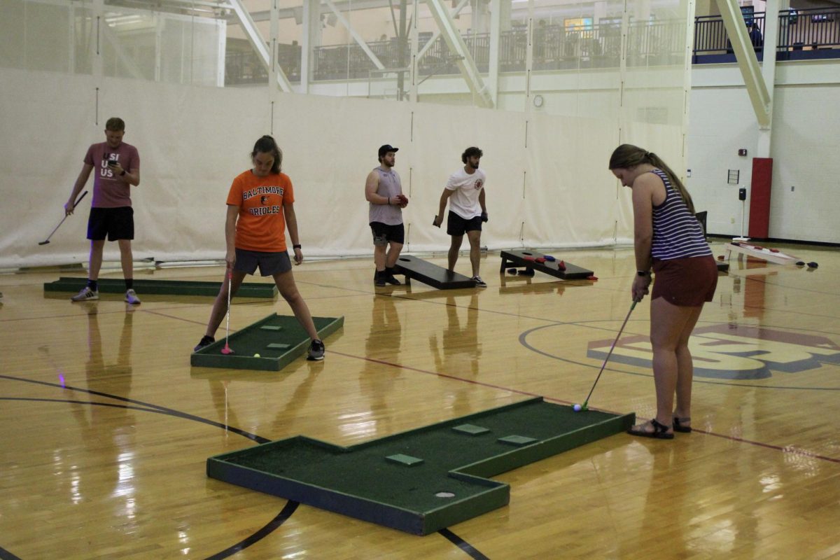 Attendees play miniature golf at the Rock the REC event Wednesday in the Recreation, Fitness and Wellness Center.
