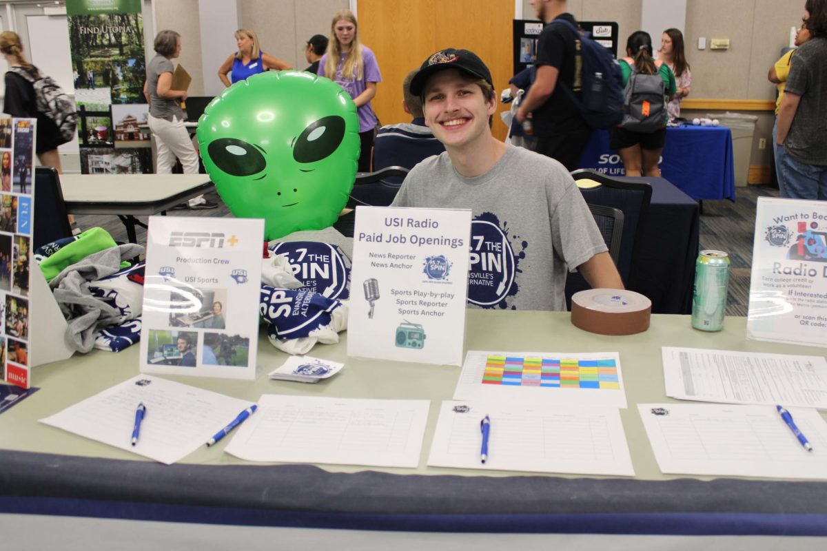 Seb Fulkerson, senior communication studies major, smiles with Kirk the Alien Wednesday while promoting 95.7 The Spin at the Part-Time Job Fair in Carter Hall. The Spin is USIs official radio station run by students.