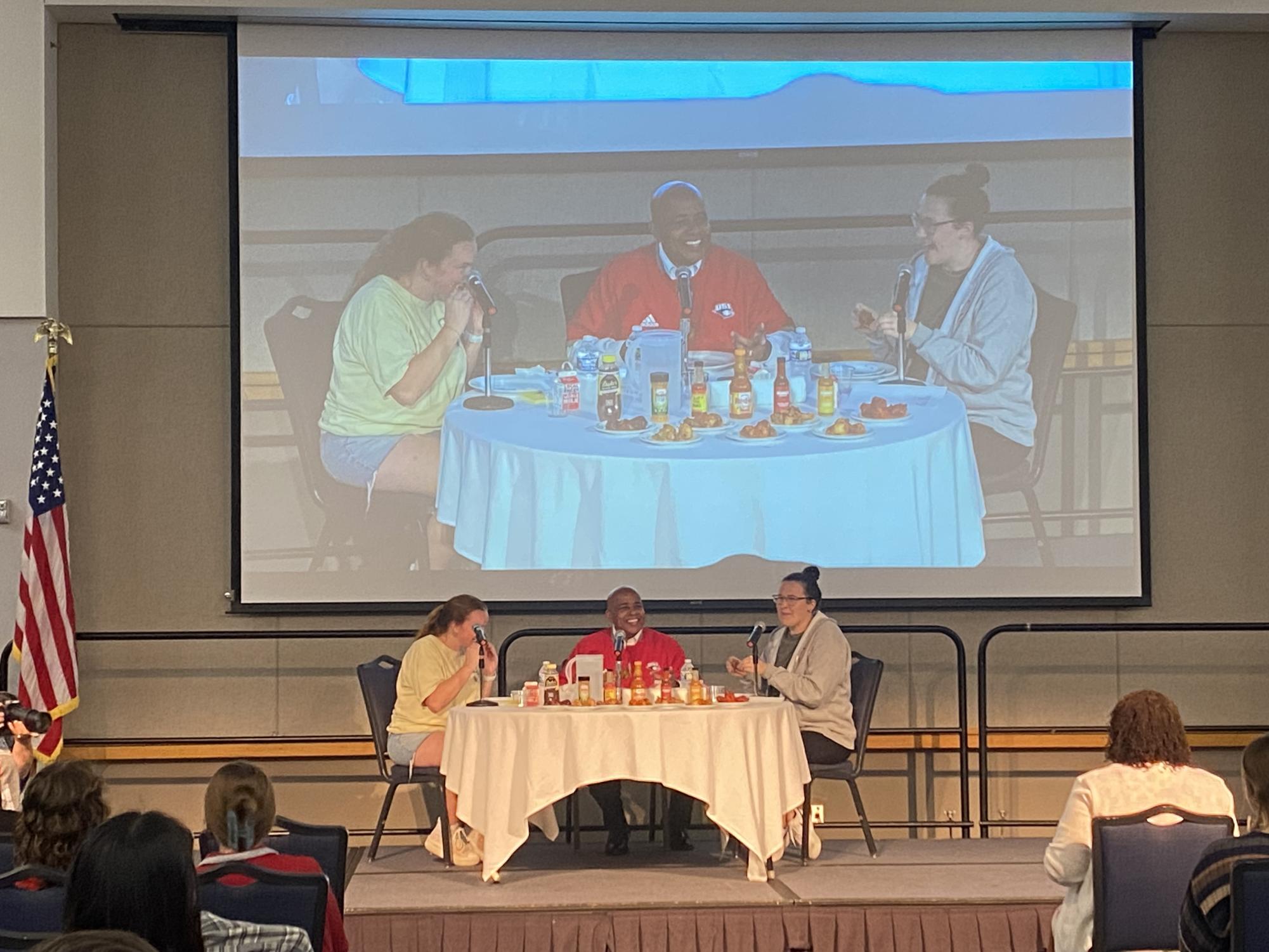 Audrey Fox, APB President, President Ronald Rochon and Laura Gobert, APB graphic designer, eat wings while Rochon answers questions Tuesday in Carter Hall located inside University Center West.