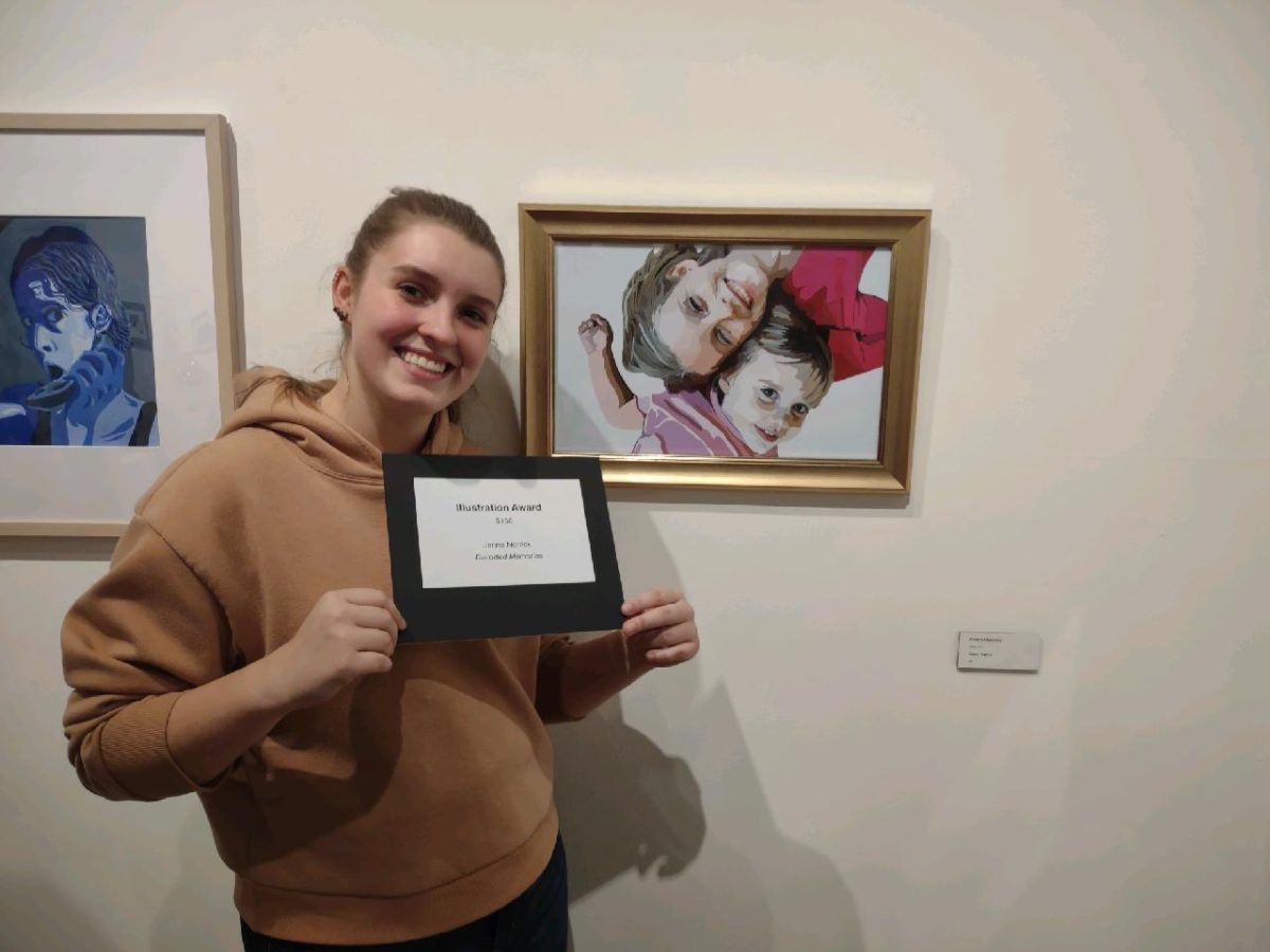 Jenna Norrick, junior graphic design major, stands next to her Wedhas Pop Art Portrait inspired painting Distorted Memories. Norrick won an illustration award for her piece. 