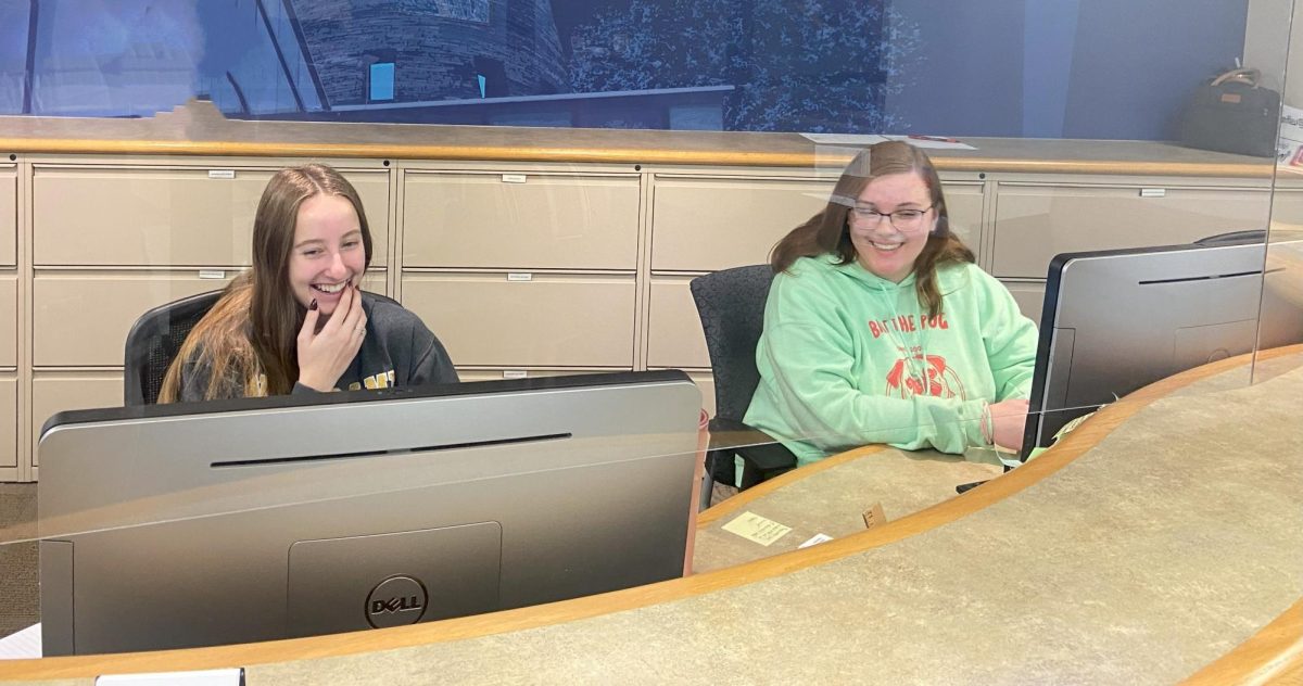 Bostyn Parkhurst, senior communications major, and Caitlyn Selby, sophomore psychology and anthropology major, sit at the Financial Assistance front desk in the Orr Center Feb. 7. 21st Century Scholars is a need-based financial assistance program that allows free admission to any Indiana public school and assisted tuition to Indiana private schools.