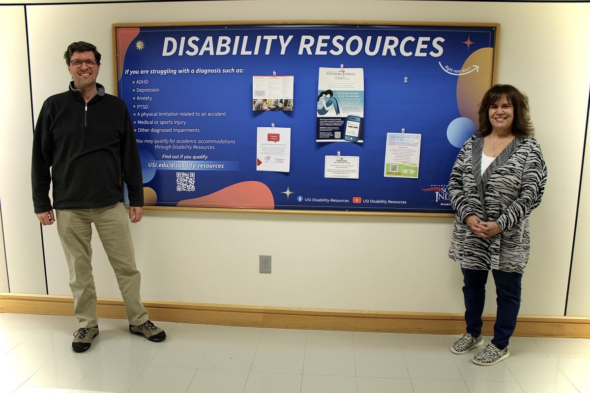 Keith Scheller, Disability Resources coordinator, and Michelle Kirk, manager of Disability Resources, stand next to a poster advertising Disability Resources. Disability Resources provides assistance to students with disabilities on campus.