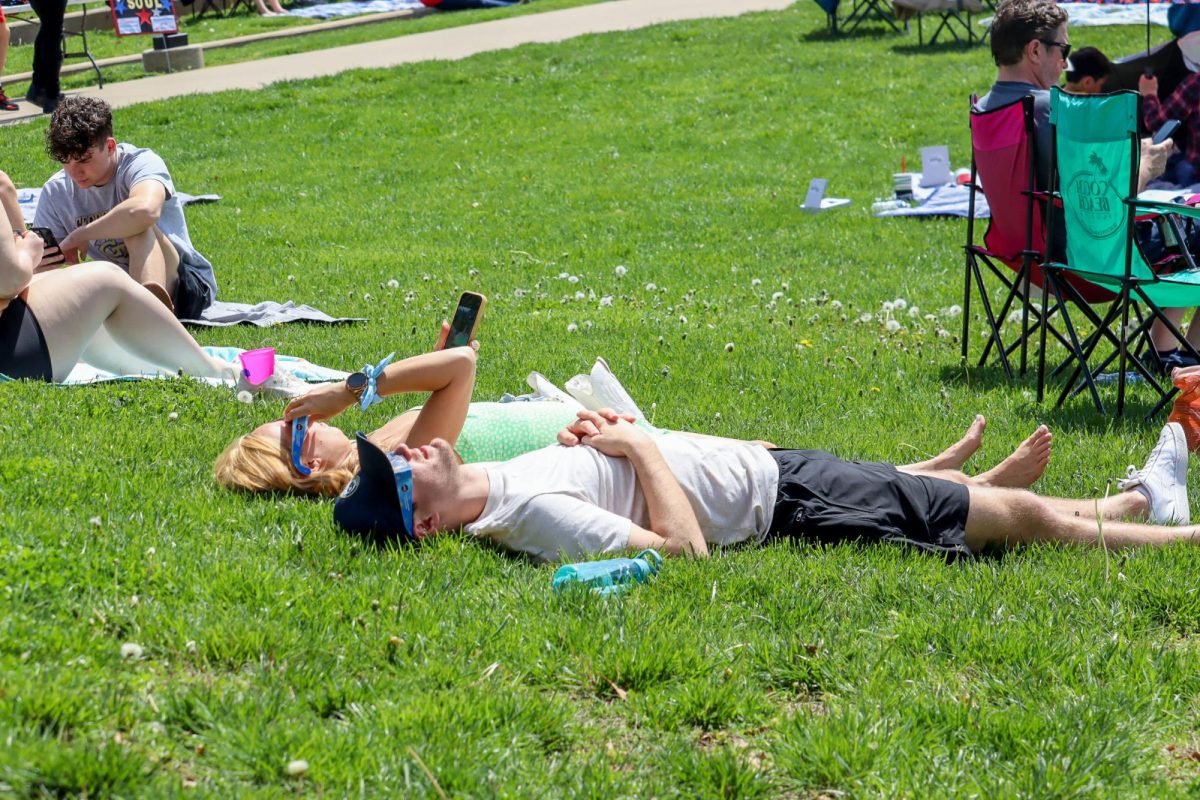 Attendees lie on The Quad to watch the solar eclipse Monday. (Photo by Peyton Peters)