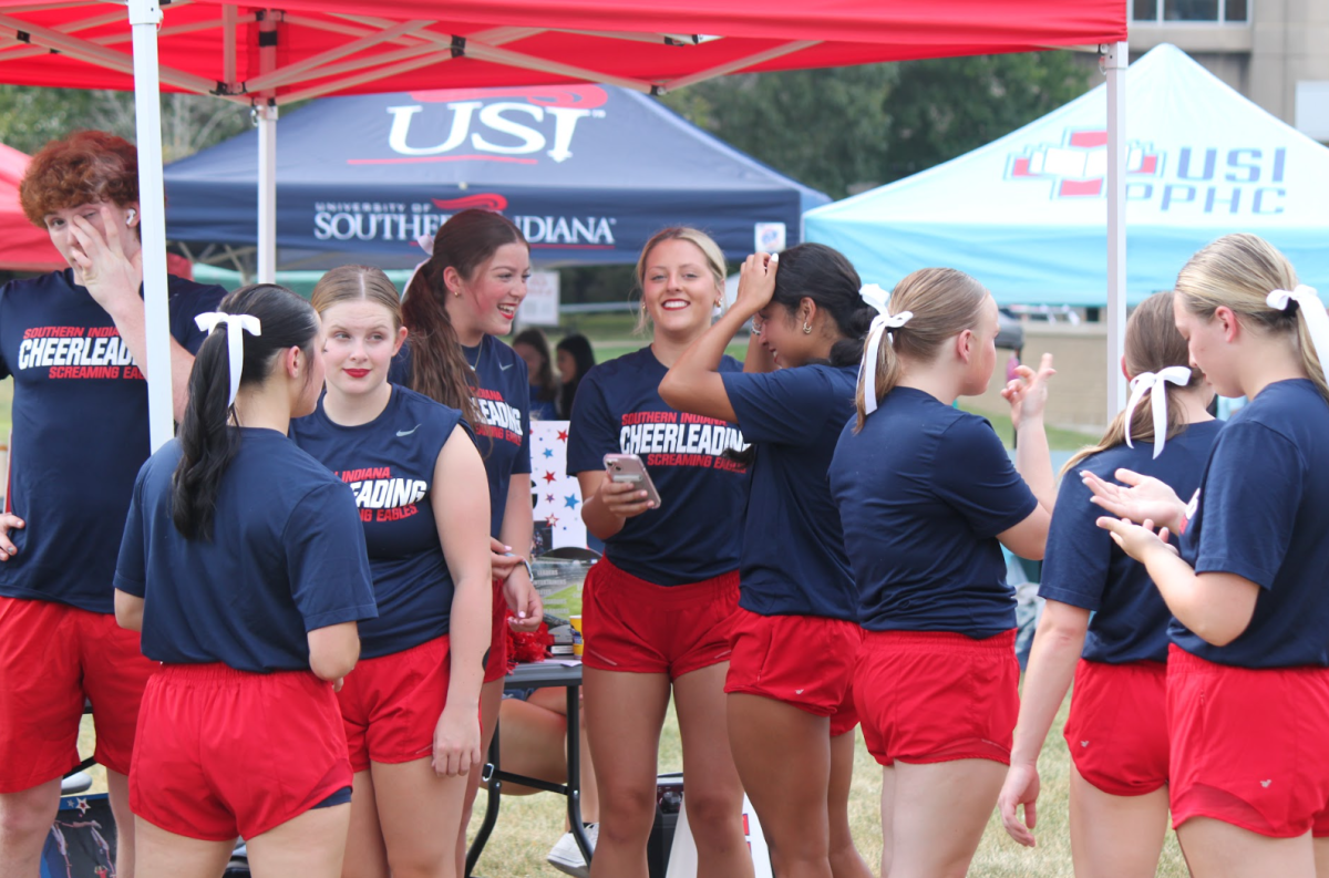 Members of the cheer team stand near their table at the Student Involvement Fair Wednesday on The Quad.