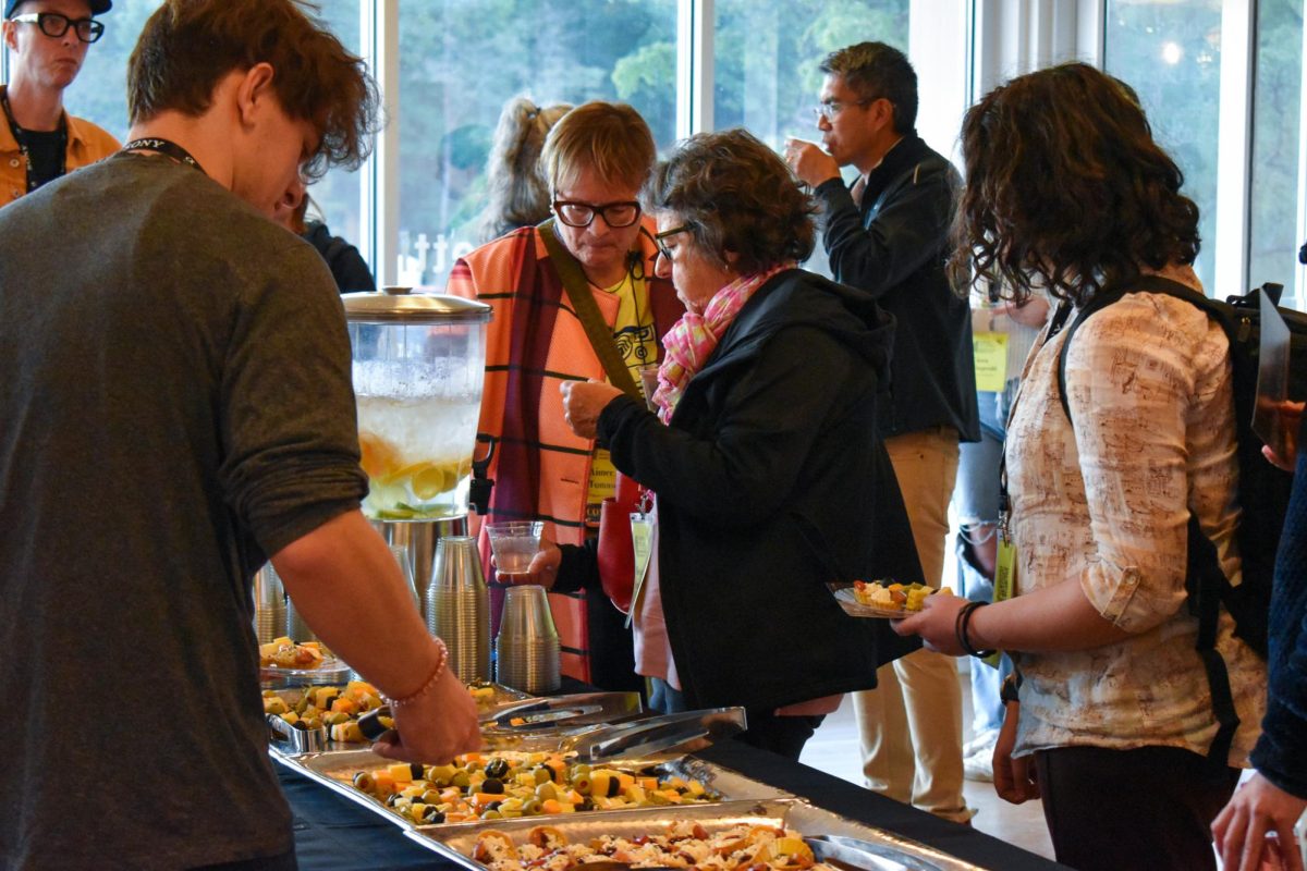 Attendees take food from the buffet at the gallery’s closing reception Friday in the Kenneth P. McCutchan Art Center/Palmina F. and Stephen S. Pace Galleries.