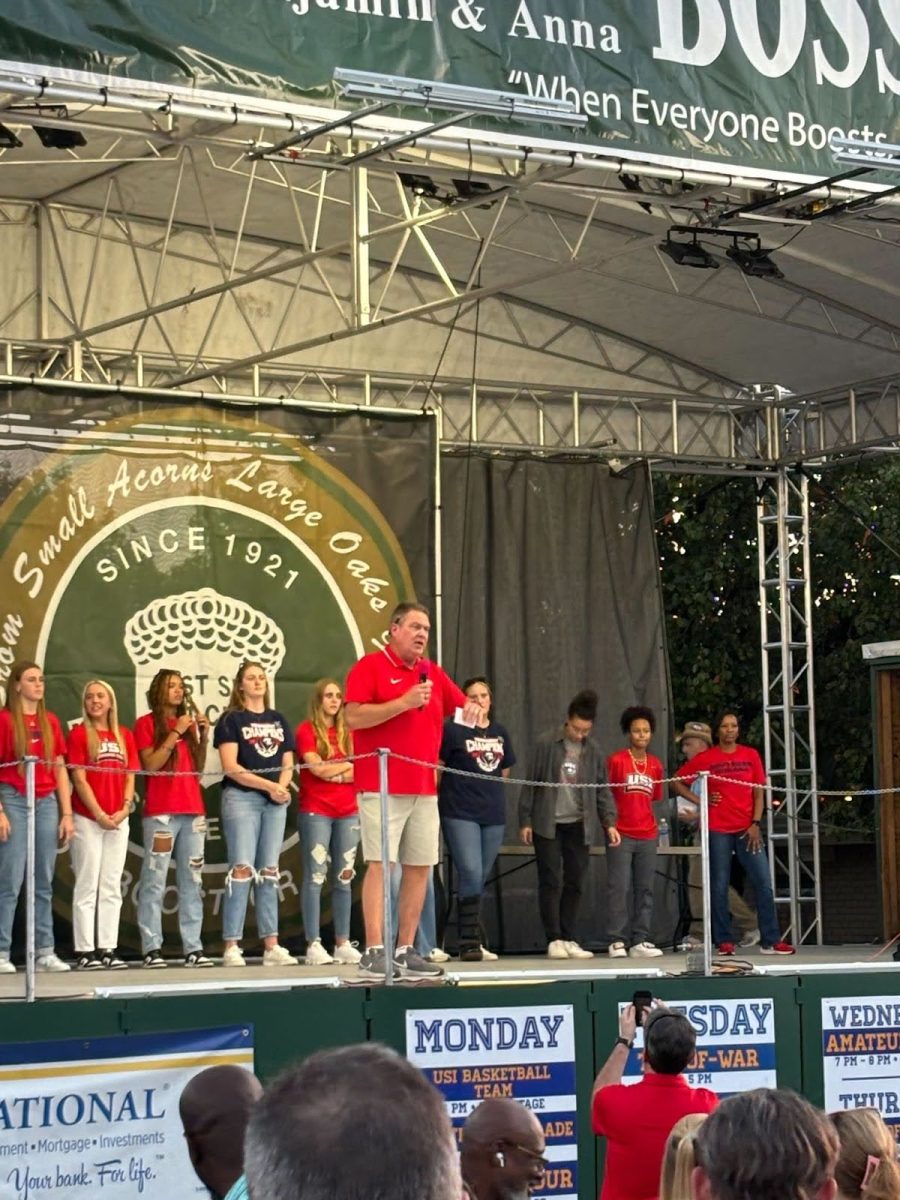 An announcer introduces the USI women's basketball team on the Benjamin and Anna Bosse Foundation Stage Oct. 11 at the West Side Nut Club Fall Festival. 