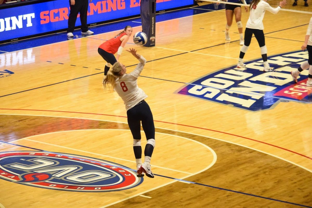 Abby Weber, senior outside hitter, performs an overhand serve toward Tennessee State University players Friday in Liberty Arena. (Photo by Alex Mendoza)
