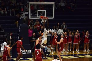 Stephen Olowoniyi, sophomore forward, dunks in traffic Friday in Liberty Arena. (Photo by Alex Mendoza)
