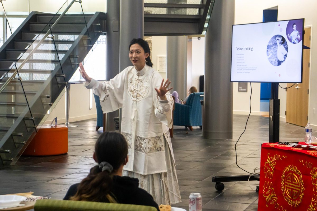 Bohan Ye, assistant professor of economics, demonstrates ways to train one’s voice before singing Thursday in the Business and Engineering Center atrium. 