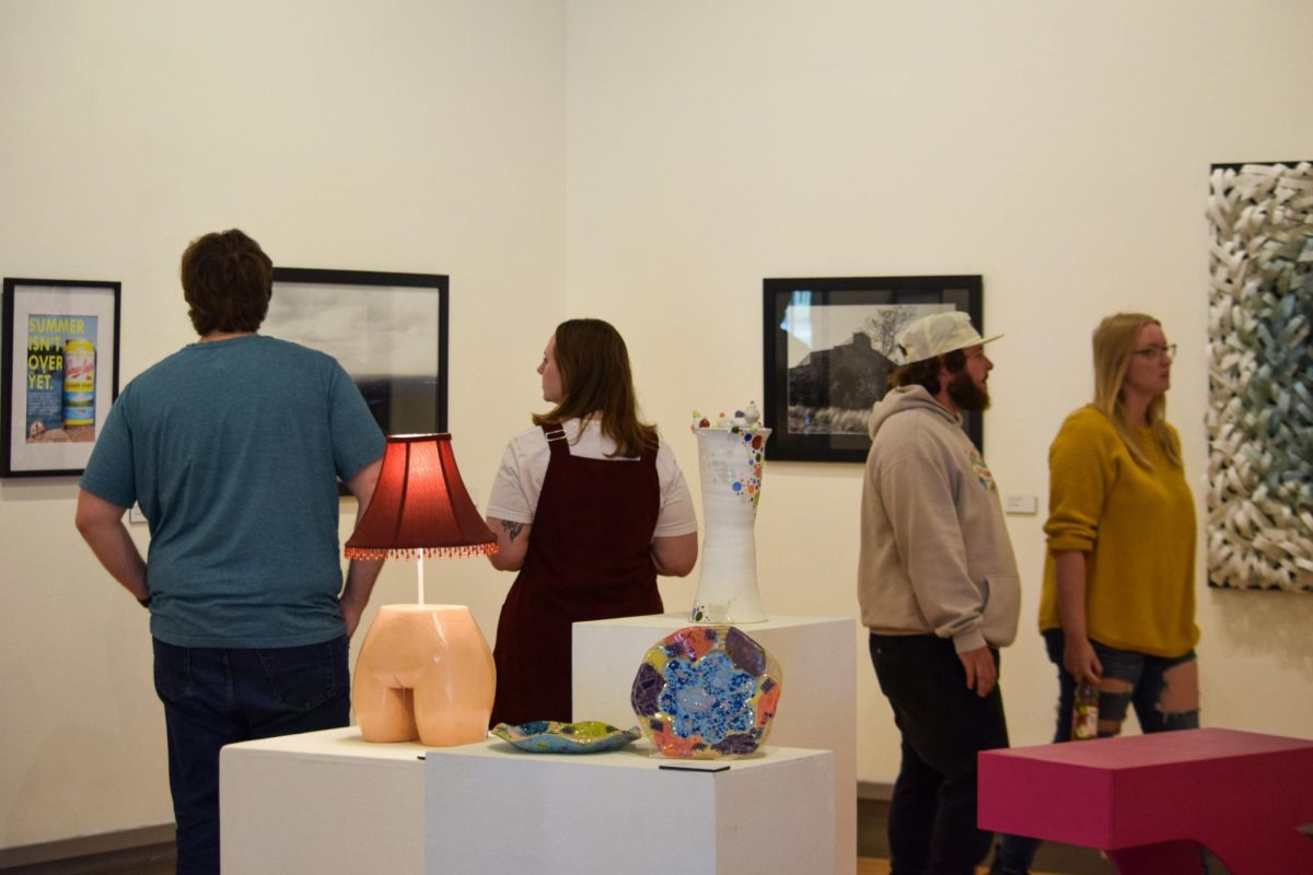 Attendees view artworks at the 55th Annual Juried Student Art Show Sunday in the Kenneth P. McCutchan Art Center. (Photo By Chloé Newman) 