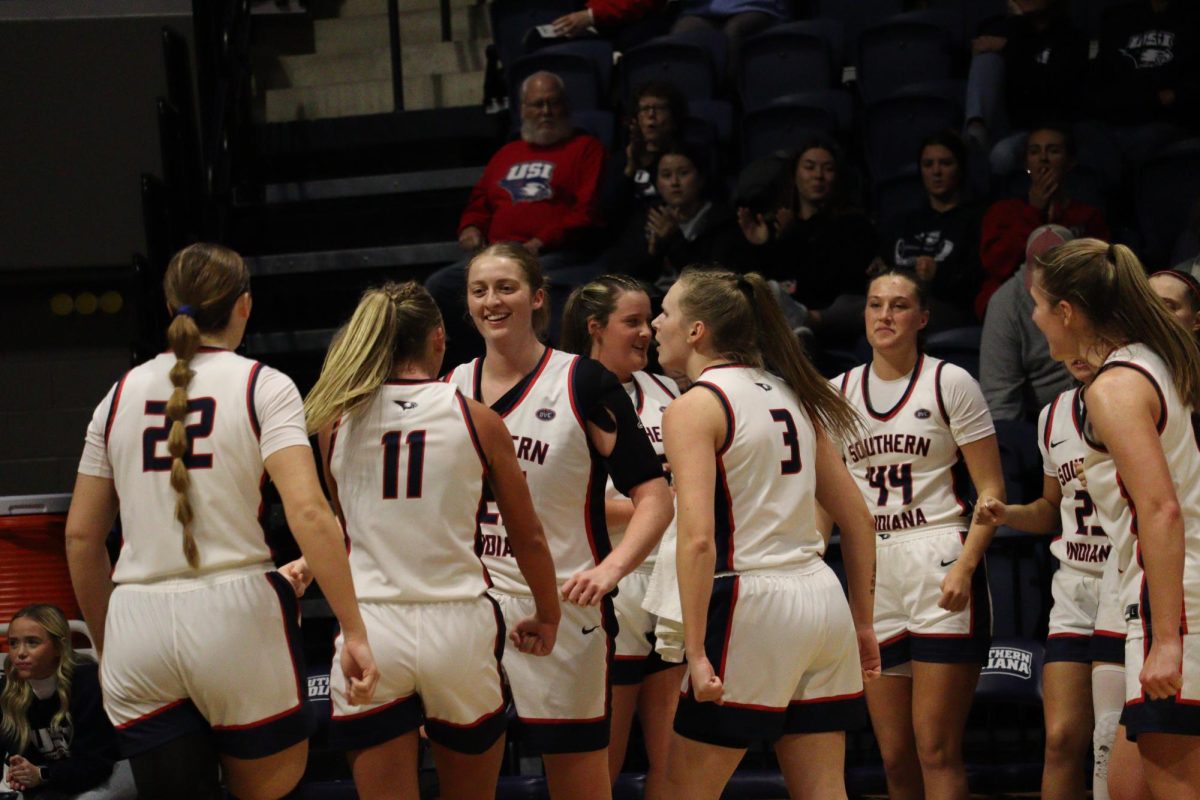 Madi Webb, graduate forward/center, is surrounded by her teammates after a late-and-one hook shot against Northern Kentucky University Saturday in Liberty Arena. (Photo by Will Kessinger) 
