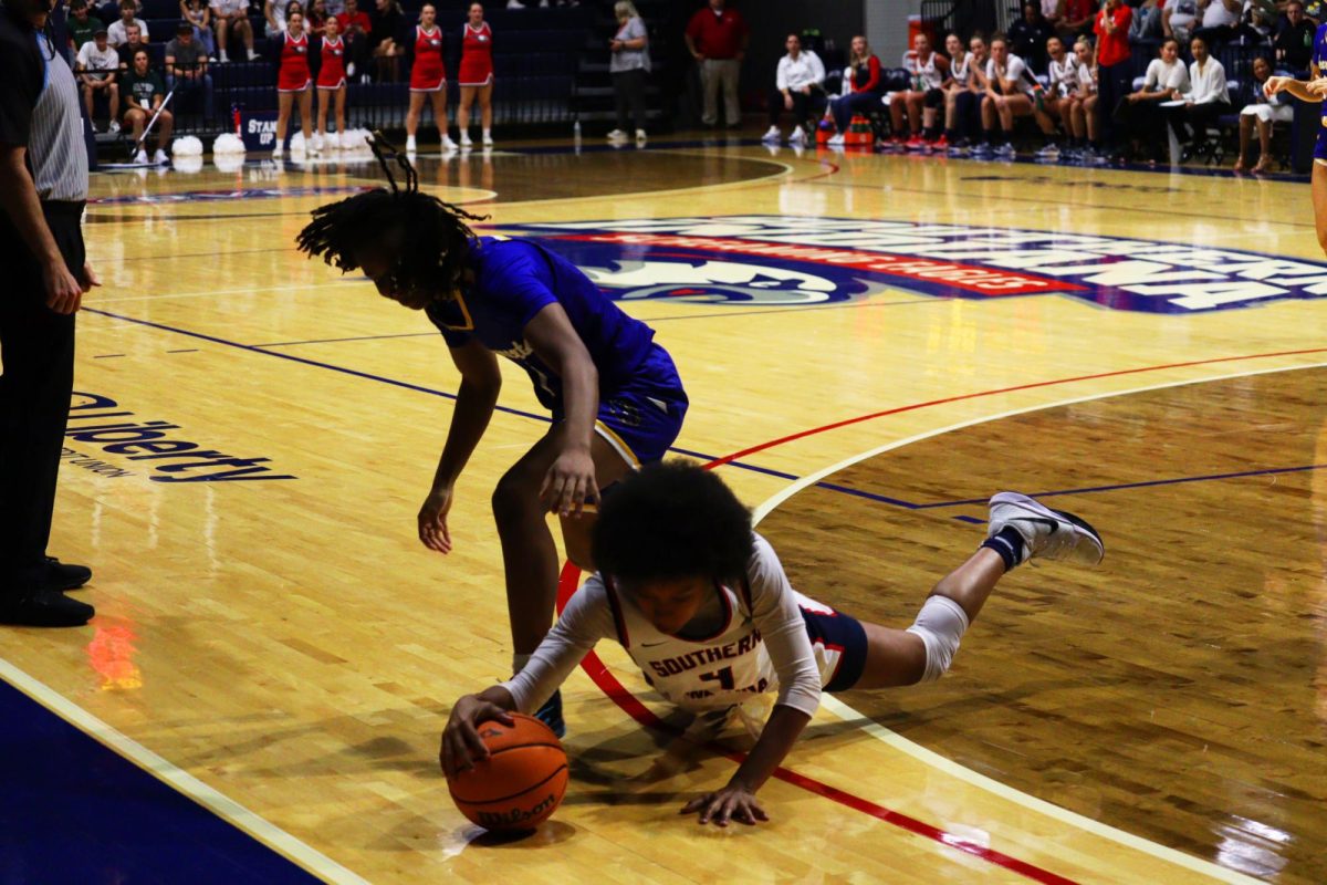 Triniti Ralson, sophomore guard, dives for a loose ball near the sideline Monday in Liberty Arena. (Photo by Will Kessinger) 
