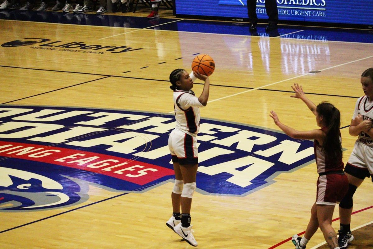 Triniti Ralston, sophomore guard, fires a top-of-the-key three-point shot while Meredith Railey, graduate forward, sets a screen on a closing Grenadier defender Friday in Liberty Arena. (Photo by Will Kessinger) 
