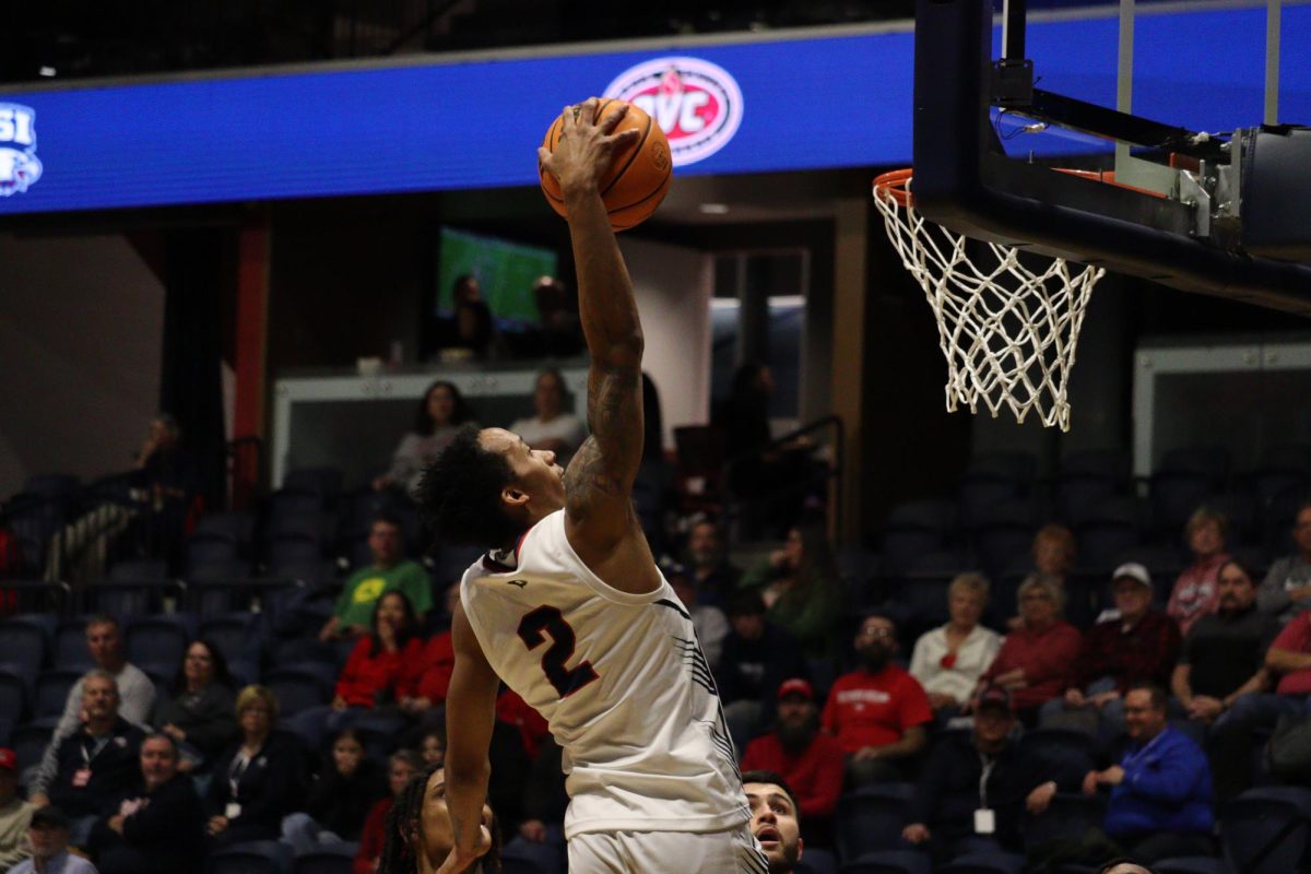 Jayland Randall, junior guard, skies through the air to complete a one-handed jam against the Phantoms Monday in Liberty Arena. (Photo by Will Kessinger)
