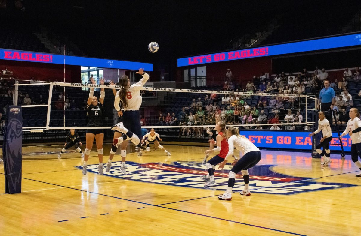 Ashby Willis, sophomore outside hitter, hits the ball over the net during a match against crosstown rival University of Evansville Sept. 20 at Liberty Arena. (Photo by Izzy Hannon)