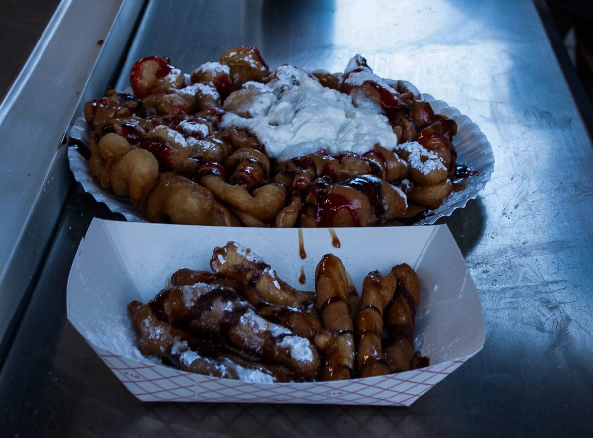 Two plates of funnel cakke lay on a table at one of the Fall Festival booths Oct. 8, 2024 at the West Side Nut Club Fall Festival. (Photo by Kai Harris)