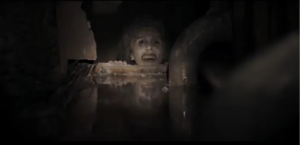 The spirit of Olga’s mother (Inma Pavon) looks at Isaac (Jonathan French) from the end of a narrow crawlspace.