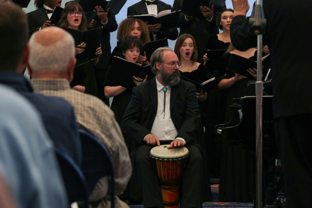 Thomas Drury, advanced instructor in music, plays a drum while the choir sings “Veni Creator Spiritus” during the fall Chamber Choir concert in the David L. Library Sunday, Oct. 26.
