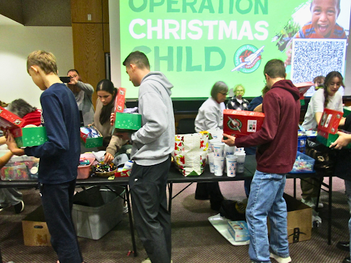 Volunteers pack shoe boxes with gifts for Operation Christmas Child during the event in the Liberal Arts building Thursday, Nov. 13.