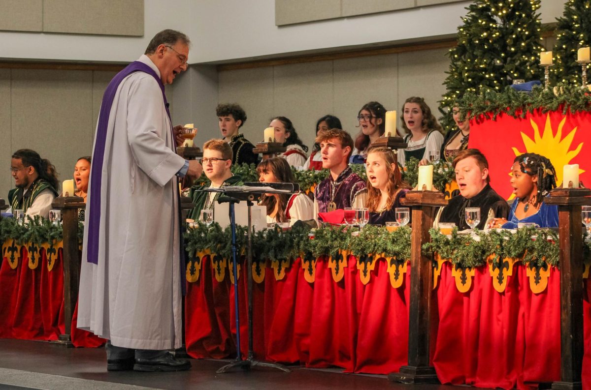 Daniel Craig, associate professor of music and director of the USI Chamber Choir, conducts the USI Chamber Choir during the 54th annual Madrigal Feaste Saturday, Dec. 6 in Carter Hall. (Photo by Izzy Hannon) 
