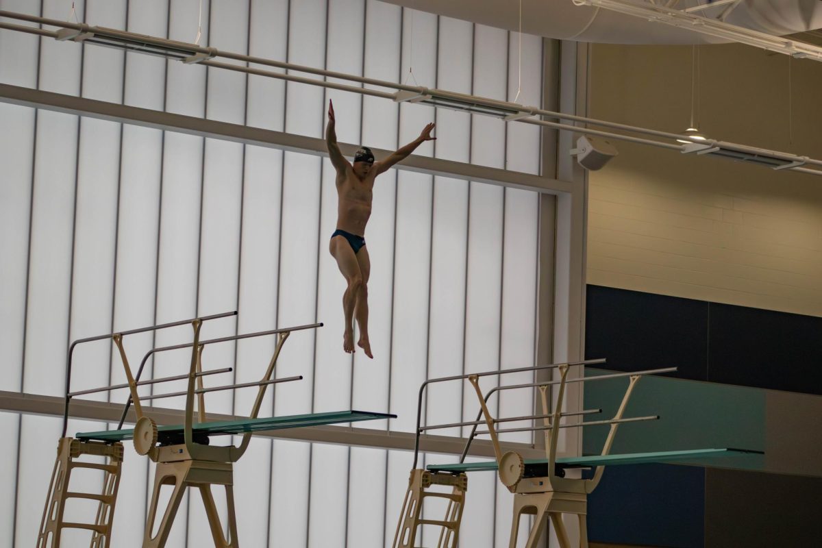 Nathan Deputy, junior diver, hurdles in the air during a five-meter dive Tuesday, Dec. 16, in the Deaconess Aquatic Center. (Photo by Amber Adams)