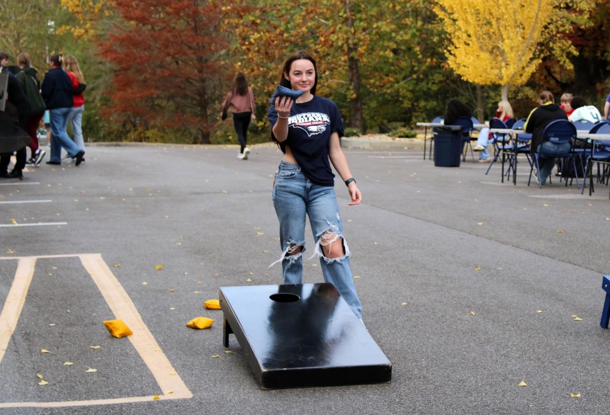 Piper Rollins, freshman business management major, plays cornhole at the First Friday Tailgate, Nov. 7, in Screaming Eagles Complex. (Photo by Izzy Hannon)