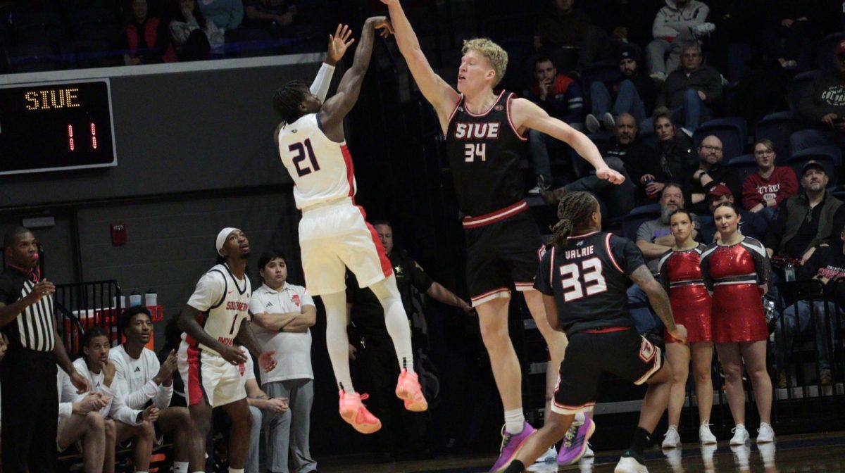 Ismail Habib, senior guard, shoots a three-pointer over a Southern Illinois University Edwardsville defender Saturday, Jan. 31, at Liberty Arena. (Photo by Anderson Schmidt)