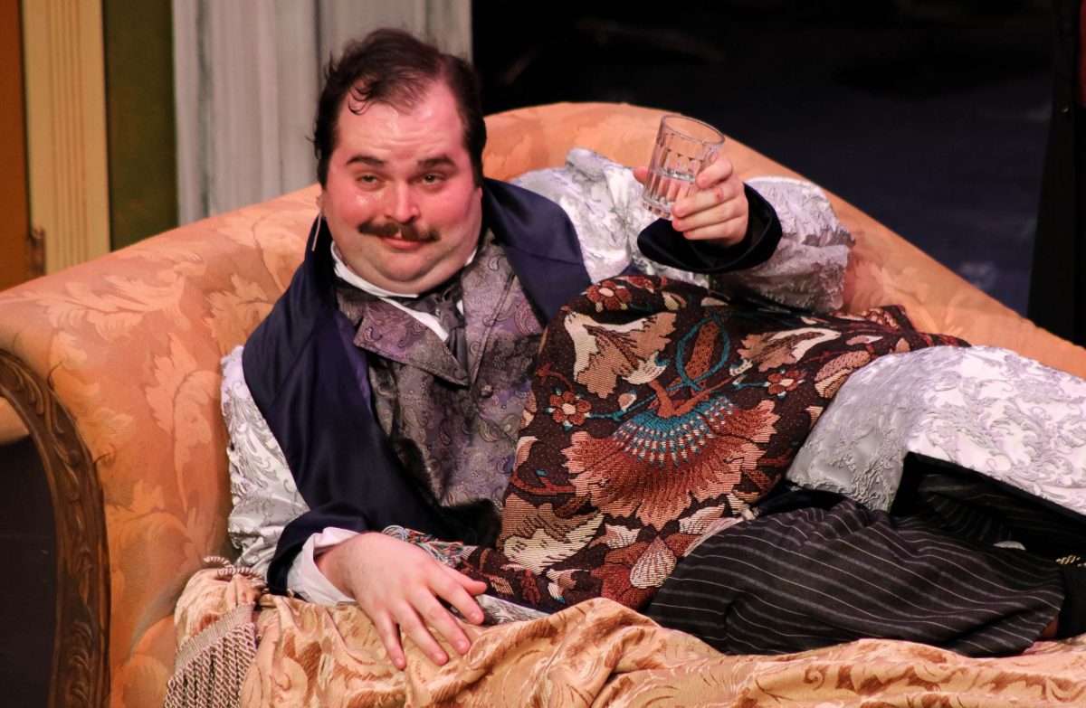 Reginald (Jonathan Elmore) raises his glass during  a rehearsal of “Farce and Follies: A USI Opera Event” in the Performance Center Friday, Jan. 30.