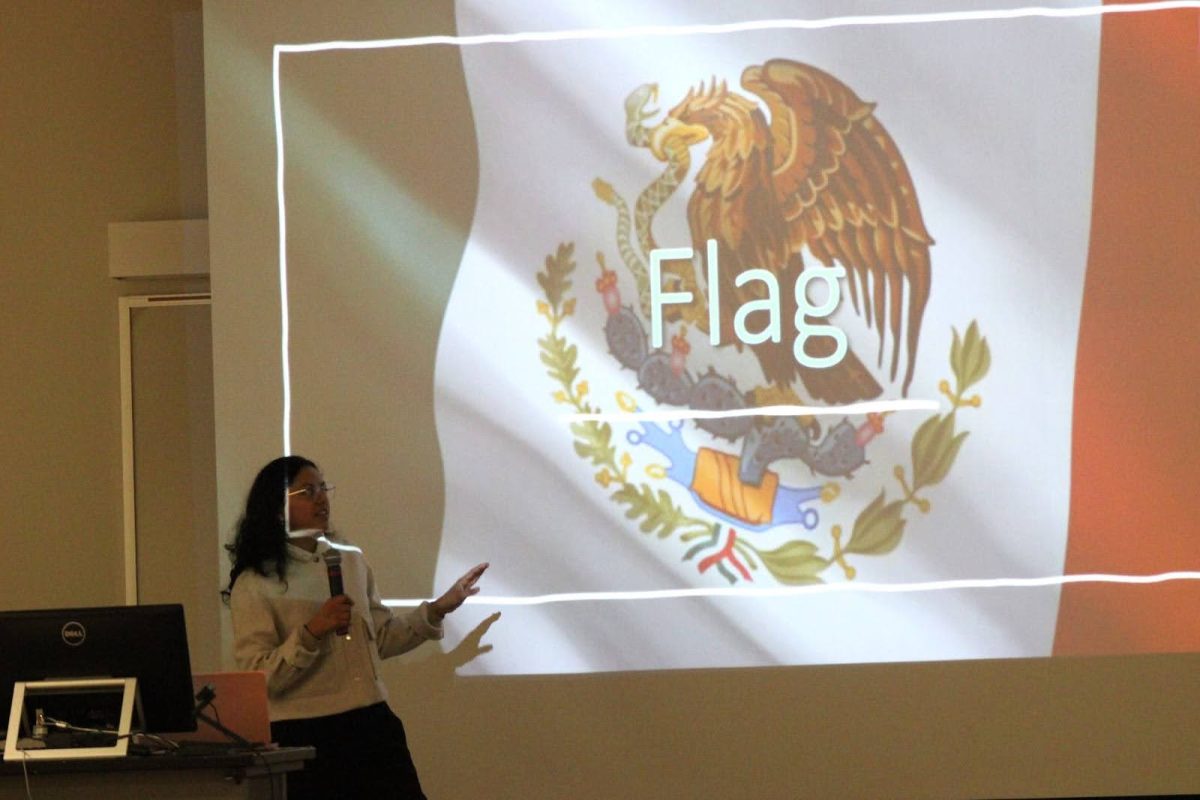 Monica Monterrosa Morales, junior computer science major, explains what the colors and symbols represented on the flag of Mexico during Culture Night, hosted by iClub, Thursday Jan. 29, at the David L. Rice Library. 