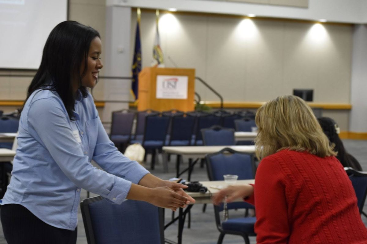 Jasmine Roland, sophomore world language and cultures major, shakes the hand of a prospective mentor during the third round of the event Wednesday, March 4 in Carter Hall. (Photo by Cade Smithson)