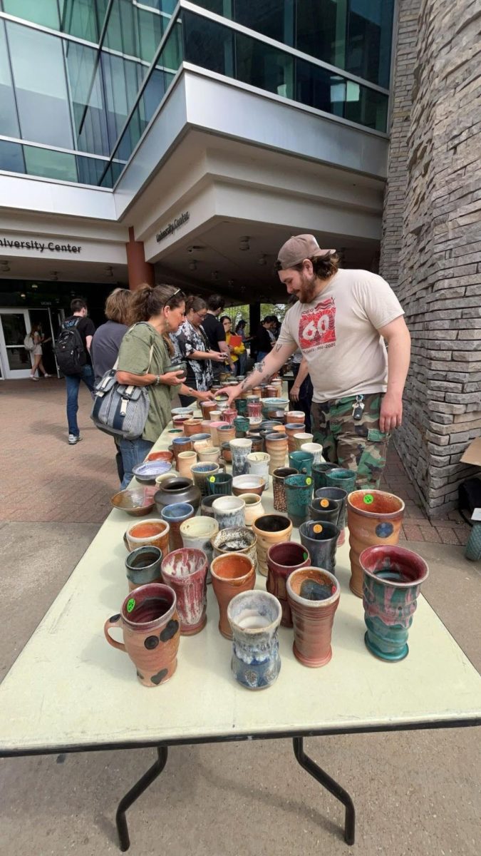 Students and attendees appreciate the pieces made by students in ceramics under the University Center Breezeway Wednesday, April 15.  