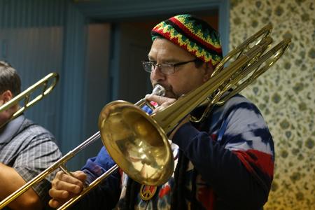 Craig Edling, a USI Pep Band member, plays the trombone dressed in costume during practice in the Grime Haus. 