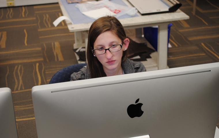 Lauren Humbert puts final touches on her senior portfolio Monday. The art major will graduate at 1 p.m. Saturday in the Physical Activities Center.